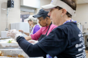 Three people in a kitchen preparing food